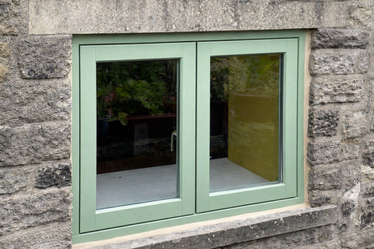 Timber casement window, green frame Green timber casement window in stone wall, double glazed wooden frame